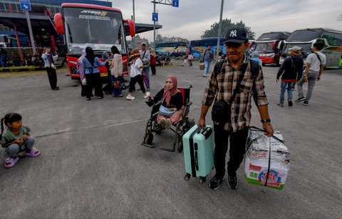 Peserta mudik gratis Kemenhub berjalan menuju bus di Terminal Pondok Cabe, Tangerang Selatan, Banten,  Kamis (27/03/2025).