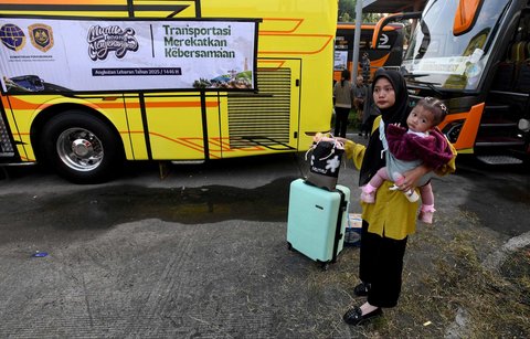Peserta mudik gratis Kemenhub berjalan menuju bus di Terminal Pondok Cabe, Tangerang Selatan, Banten,  Kamis (27/03/2025).