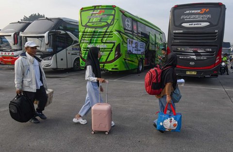 Peserta mudik gratis Kemenhub berjalan menuju bus di Terminal Pondok Cabe, Tangerang Selatan, Banten,  Kamis (27/03/2025).