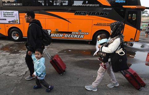 Peserta mudik gratis Kemenhub berjalan menuju bus di Terminal Pondok Cabe, Tangerang Selatan, Banten,  Kamis (27/03/2025).
