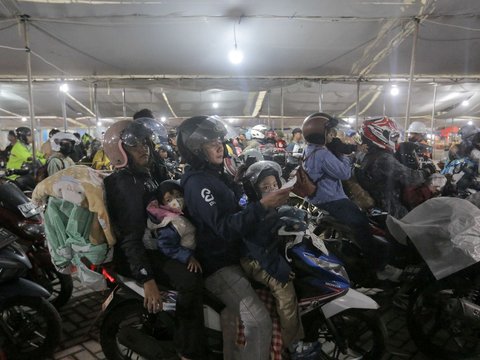 Pemudik dengan sepeda motornya mengantre untuk menaiki kapal selama arus mudik Lebaran 2025 di Pelabuhan Ciwandan, Banten, Kamis (27/3/2025) malam.