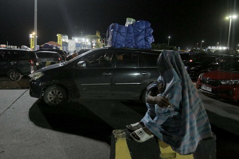 Pemudik beristirahat saat mengantre panjang untuk menyeberang ke Pelabuhan Bakauheni, Lampung, di Pelabuhan Merak, Banten, Jumat (28/3/2025) dini hari WIB.