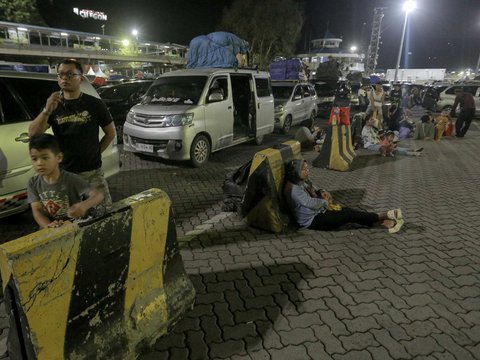 Pemudik beristirahat saat mengantre panjang untuk menyeberang ke Pelabuhan Bakauheni, Lampung, di Pelabuhan Merak, Banten, Jumat (28/3/2025) dini hari WIB.
