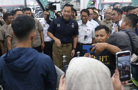 Menteri Koordinator Bidang Infrastruktur, Agus Harimurti Yudhoyono berbincang dengan penumpak kereta api jarak jauh saat memantau arus mudik Lebaran 2025 di Stasiun Pasar Senen, Jakarta, Jumat (28/3/2025).