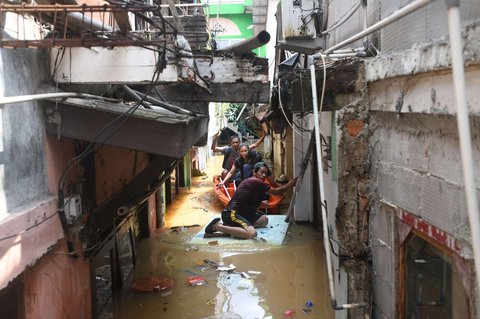Warga dievakuasi menggunakan perahu saat banjir merendam permukiman di sekitar Sungai Ciliwung, Jakarta, Senin (3/3/2025). Banjir akibat luapan Sungai Ciliwung merendam sejumlah wilayah di Jakarta dengan ketinggian mencapai 2 meter.