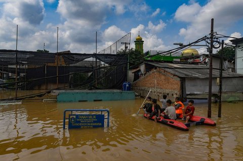 Anak-anak menaiki perahu karet saat banjir merendam permukiman di sekitar Sungai Ciliwung, Jakarta, Senin (3/3/2025). Banjir akibat luapan Sungai Ciliwung merendam sejumlah wilayah di Jakarta dengan ketinggian mencapai 2 meter.