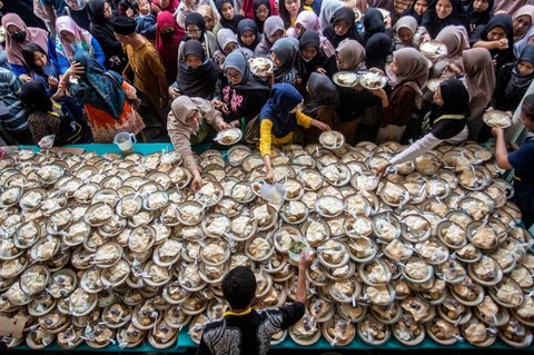 Umat Muslim menerima makanan gratis untuk berbuka puasa selama Ramadan di Masjid Jogokariyan di Yogyakarta, pada 2 Maret 2025.