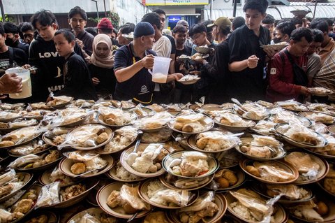 Umat Muslim menerima makanan gratis untuk berbuka puasa selama Ramadan di Masjid Jogokariyan di Yogyakarta, pada 2 Maret 2025.