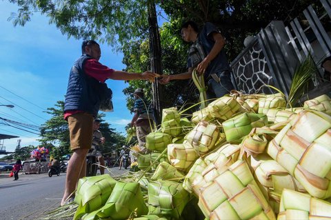 Pedagang melayani pembelian kulit ketupat di Pasar Pondok Labu, Jakarta Selatan, Minggu (30/03/2025).