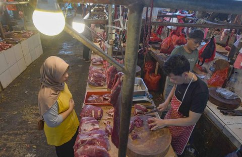 Pedagang melayani pembeli daging sapi di Pasar Pondok Labu, Jakarta Selatan, Minggu (30/03/2025).
