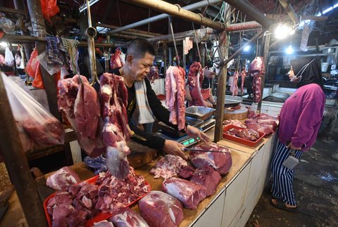 Pedagang melayani pembeli daging sapi di Pasar Pondok Labu, Jakarta Selatan, Minggu (30/03/2025).