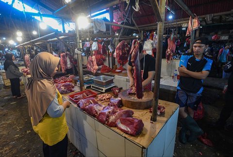 Pedagang melayani pembeli daging sapi di Pasar Pondok Labu, Jakarta Selatan, Minggu (30/03/2025).