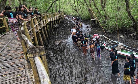 Warga adat Desa Kedonganan saa mengikuti kegiatan tradisi mandi lumpur di Desa Kedonganan, Badung, Bali, Minggu (30/03/2025).