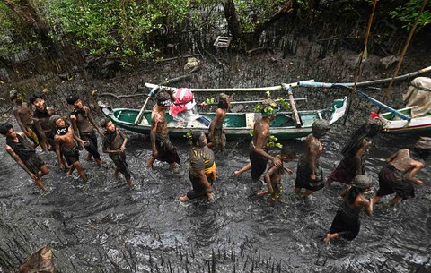 Warga saat mengikuti  kegiatan tradisi mandi lumpur di Desa Kedonganan, Badung, Bali, Minggu (30/03/2025).