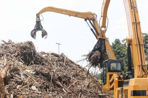 Petugas menggunakan alat berat saat memindahkan tumpukan sampah, yang telah diangkut dari Sungai Ciliwung, ke atas truk di Saringan Sampah TB Simatupang (SSTBS), Jakarta, Rabu (5/3/2025).