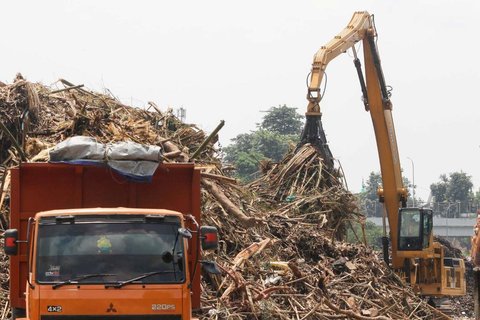 Petugas menggunakan alat berat saat memindahkan tumpukan sampah, yang telah diangkut dari Sungai Ciliwung, ke atas truk di Saringan Sampah TB Simatupang (SSTBS), Jakarta, Rabu (5/3/2025).