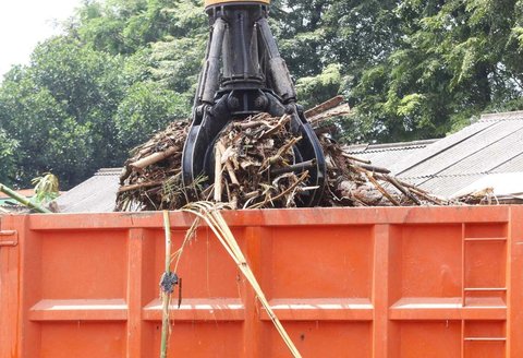 Petugas menggunakan alat berat saat memindahkan tumpukan sampah, yang telah diangkut dari Sungai Ciliwung, ke atas truk di Saringan Sampah TB Simatupang (SSTBS), Jakarta, Rabu (5/3/2025).
