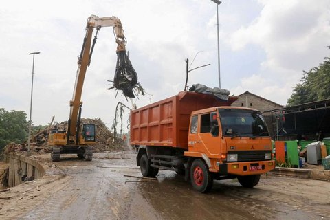 Petugas menggunakan alat berat saat memindahkan tumpukan sampah, yang telah diangkut dari Sungai Ciliwung, ke atas truk di Saringan Sampah TB Simatupang (SSTBS), Jakarta, Rabu (5/3/2025).