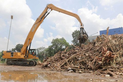Petugas menggunakan alat berat saat memindahkan tumpukan sampah, yang telah diangkut dari Sungai Ciliwung, ke atas truk di Saringan Sampah TB Simatupang (SSTBS), Jakarta, Rabu (5/3/2025).