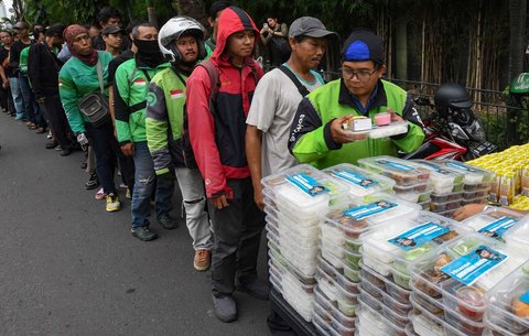 Warga mengantre untuk mendapatkan takjil yang dibagikan gratis di Jalan Asia Afrika, Jakarta, Jumat (7/3/2025).