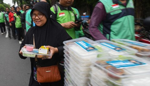 Warga mengantre untuk mendapatkan takjil yang dibagikan gratis di Jalan Asia Afrika, Jakarta, Jumat (7/3/2025).