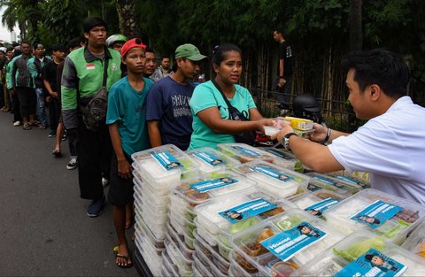 Warga mengantre untuk mendapatkan takjil yang dibagikan gratis di Jalan Asia Afrika, Jakarta, Jumat (7/3/2025).