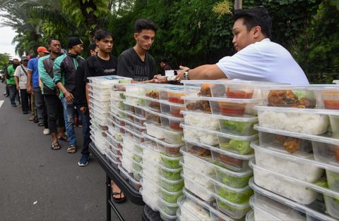 Warga mengantre untuk mendapatkan takjil yang dibagikan gratis di Jalan Asia Afrika, Jakarta, Jumat (7/3/2025).