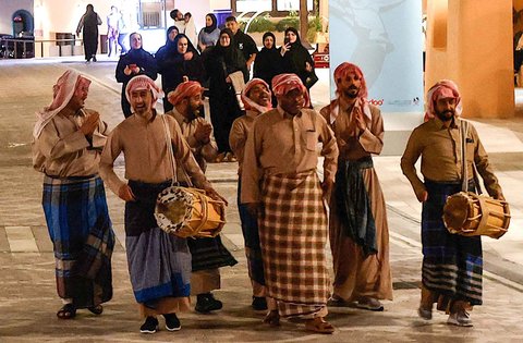 Warga memainkan drum dan menyanyikan lagu-lagu tradisional saat membangunkan sahur di kawasan pelabuhan Old Doha, Qatar (07/03/2025) waktu setempat
