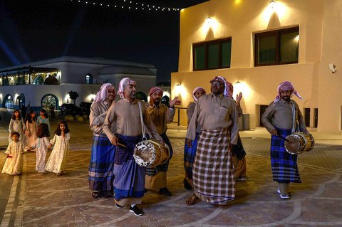 Warga memainkan drum dan menyanyikan lagu-lagu tradisional saat membangunkan sahur di kawasan pelabuhan Old Doha, Qatar (07/03/2025) waktu setempat