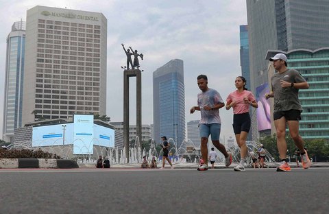 Warga berolahraga di area Hari Bebas Kendaraan Bermotor, Bundaran HI, Jakarta, Minggu (9/3/2025).