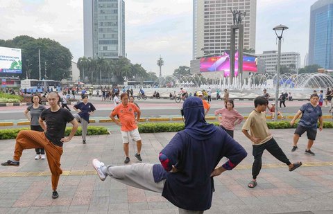 Warga berolahraga di area Hari Bebas Kendaraan Bermotor, Bundaran HI, Jakarta, Minggu (9/3/2025).