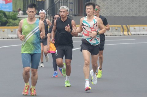 Warga berolahraga di area Hari Bebas Kendaraan Bermotor, Bundaran HI, Jakarta, Minggu (9/3/2025).