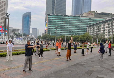 Warga berolahraga di area Hari Bebas Kendaraan Bermotor, Bundaran HI, Jakarta, Minggu (9/3/2025).