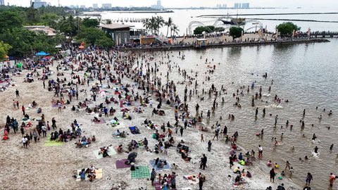 Sejumlah warga berwisata di Pantai Ancol Taman Impian, Jakarta, pada Selasa (1/4/2025) atau hari kedua libur Lebaran 2025. Pantai Ancol Taman Impian, Jakarta, menjadi salah satu destinasi wisata favorit warga saat libur Lebaran.