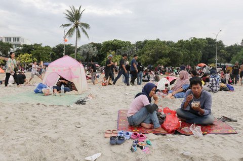 Sejumlah warga berwisata di Pantai Ancol Taman Impian, Jakarta, pada Selasa (1/4/2025) atau hari kedua libur Lebaran 2025. Pantai Ancol Taman Impian, Jakarta, menjadi salah satu destinasi wisata favorit warga saat libur Lebaran.