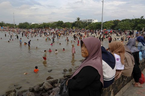 Sejumlah warga berwisata di Pantai Ancol Taman Impian, Jakarta, pada Selasa (1/4/2025) atau hari kedua libur Lebaran 2025. Pantai Ancol Taman Impian, Jakarta, menjadi salah satu destinasi wisata favorit warga saat libur Lebaran.