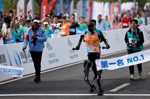Robot Humanoid Tiangong Ultra berlari melintasi garis finis saat lomba lari setengah maraton robot humanoid di Beijing,  China,  (19/04/2025).