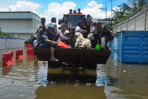Penumpang kapal penyeberangan dievakuasi menggunakan buldoser ketika banjir rob selama beberapa hari merendam kawasan Muara Angke, Jakarta Utara, pada Senin (18/11/2024).