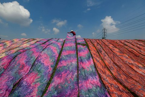 Pekerja menjemur kain warna-warni di sentra industri rumahan Desa Krajan, Mojolaban, Sukoharjo, Jawa Tengah, pada 25 April 2025.