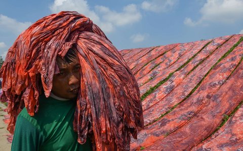 Pekerja menjemur kain warna-warni di sentra industri rumahan Desa Krajan, Mojolaban, Sukoharjo, Jawa Tengah, pada 25 April 2025.