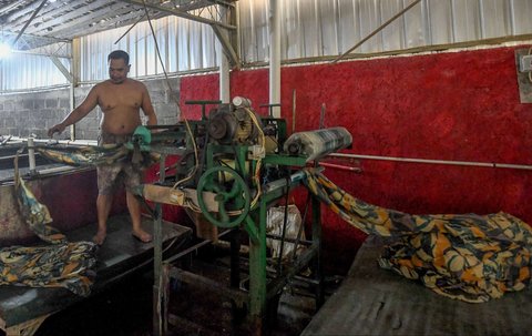 Pekerja memproduksi kain warna-warni di sentra industri rumahan Desa Krajan, Mojolaban, Sukoharjo, Jawa Tengah, pada 25 April 2025.