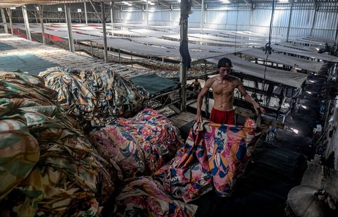 Pekerja menggulung kain warna-warni di sentra industri rumahan Desa Krajan, Mojolaban, Sukoharjo, Jawa Tengah, pada 25 April 2025.