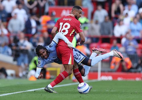 Pemain Liverpool Cody Gakpo berebut bola dengan pemain Tottenham Hotspur Djed Spence.