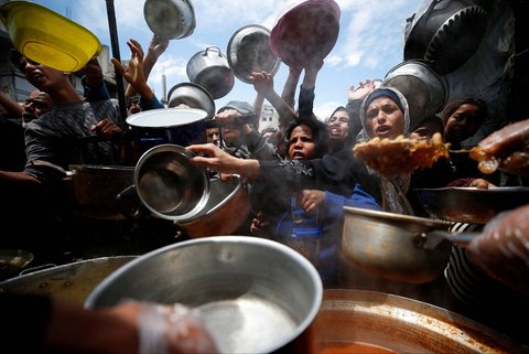 Warga Palestina antri mengambil  makanan yang dimasak di  Dapur Amal, di Beit Lahiya, Jalur Gaza utara, Senin (28/04/2025).
