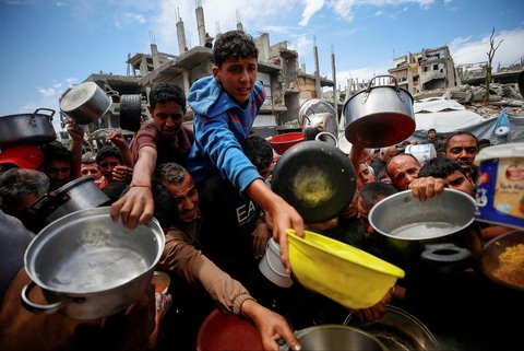 Warga Palestina antri mengambil  makanan yang dimasak di  Dapur Amal, di Beit Lahiya, Jalur Gaza utara, Senin (28/04/2025).