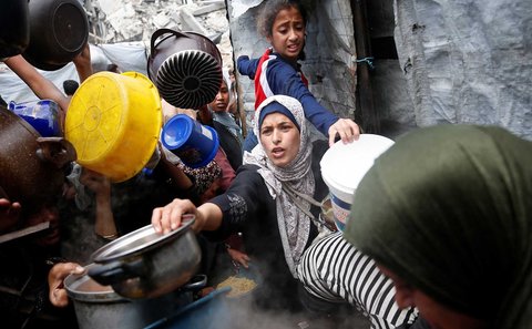 Warga Palestina antri mengambil  makanan yang dimasak di  Dapur Amal, di Beit Lahiya, Jalur Gaza utara, Senin (28/04/2025).