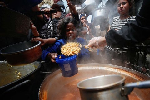 Warga Palestina antri mengambil  makanan yang dimasak di  Dapur Amal, di Beit Lahiya, Jalur Gaza utara, Senin (28/04/2025).