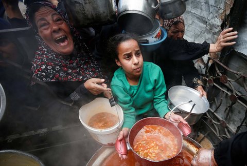 Warga Palestina antri mengambil  makanan yang dimasak di  Dapur Amal, di Beit Lahiya, Jalur Gaza utara, Senin (28/04/2025).