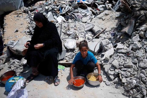 Warga Palestina antri mengambil  makanan yang dimasak di  Dapur Amal, di Beit Lahiya, Jalur Gaza utara, Senin (28/04/2025).