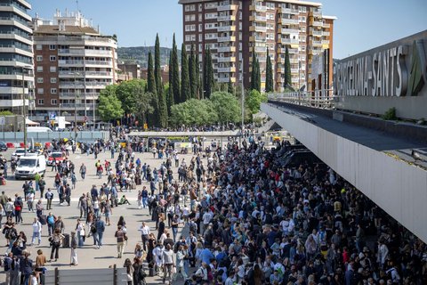 Orang-orang mendengarkan radio melalui pengeras suara di luar stasiun kereta Barcelona-Sants selama pemadaman listrik besar-besaran, pada 28 April 2025.